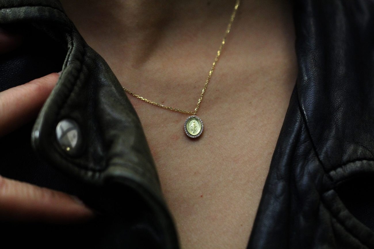 Collier médaillon Madonne Eva porté sous un blouson de cuir