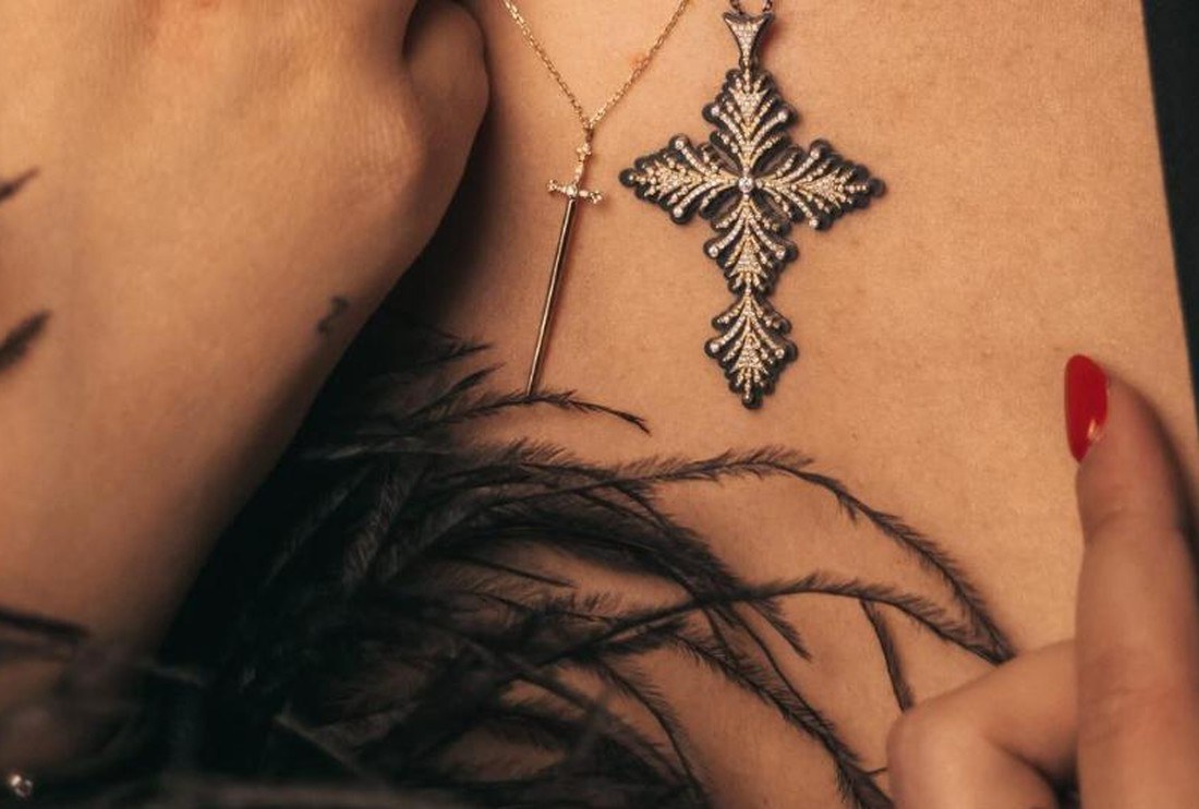 Croix Pinta portée sur la peau, plumes noires