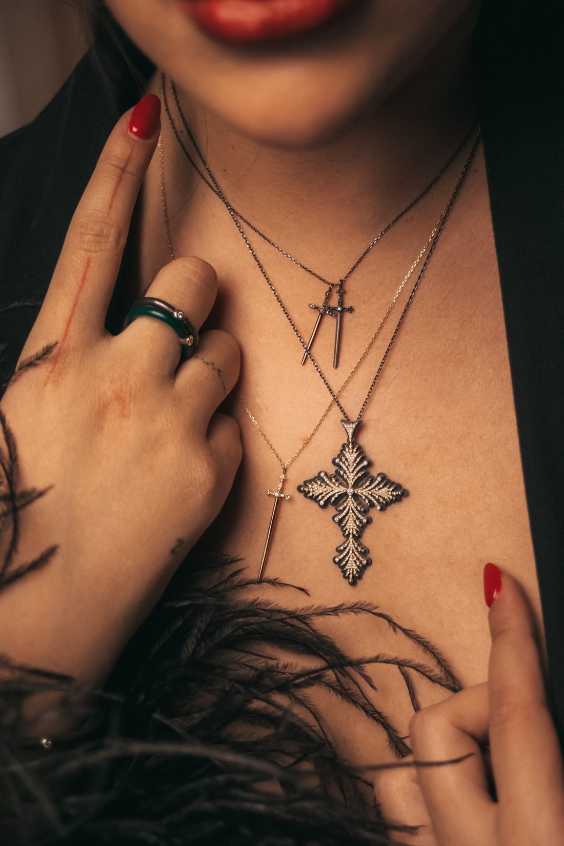 Croix Pinta portée avec les dagues Jaeger, ongles rouges et plumes noires