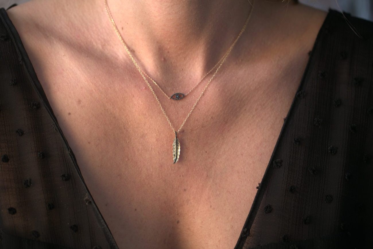 Collier Eye porté avec une plume, haut noir transparent
